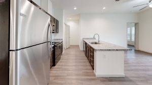a kitchen with stainless steel appliances and wood floors at The Garden Creek Apartments