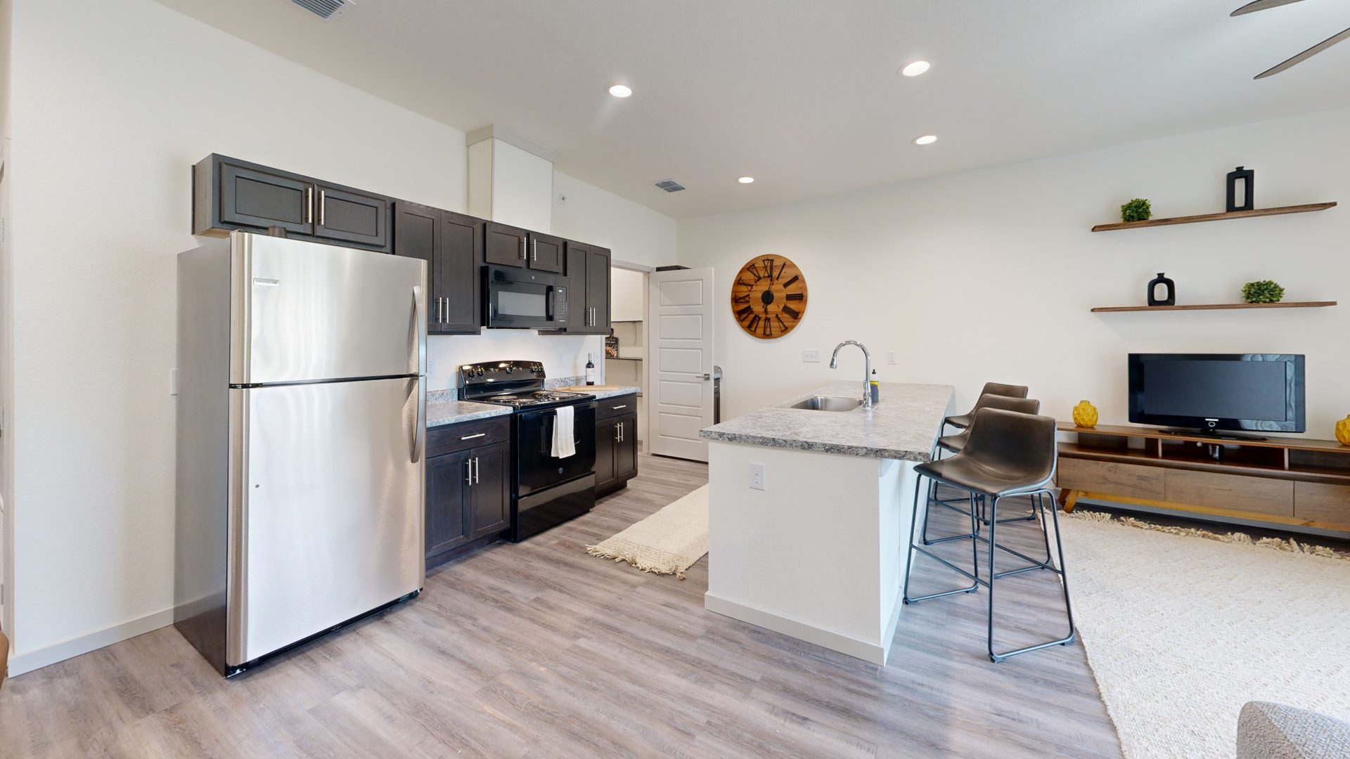 a kitchen with a refrigerator, stove, microwave and sink at The Garden Creek Apartments