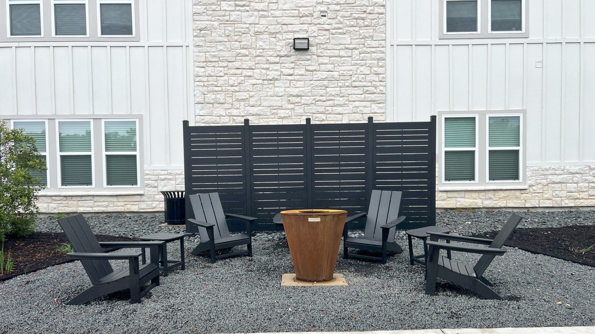 a patio with chairs and a fire pit at The Garden Creek Apartments